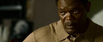 Movie still from “Cleaner” (2007), directed by Renny Harlin – An older man in a brown shirt looking at the camera; Close Up shot, Over the shoulder angle