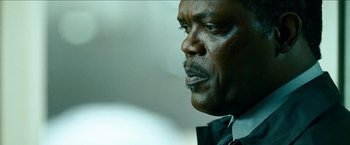 Movie still from “Cleaner” (2007), directed by Renny Harlin – A man's face in a suit and tie; Close Up shot, Low angle
