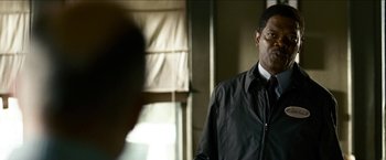Movie still from “Cleaner” (2007), directed by Renny Harlin – A man standing in a room looking at the camera; Close Up shot, Over the shoulder angle