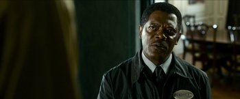 Movie still from “Cleaner” (2007), directed by Renny Harlin – A man that is wearing a suit and tie; Close Up shot, Over the shoulder angle