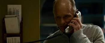 Movie still from “Cleaner” (2007), directed by Renny Harlin – An older man talking on a phone while standing next to a wall; Close Up shot, Low angle