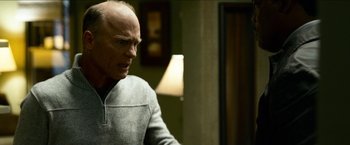 Movie still from “Cleaner” (2007), directed by Renny Harlin – An older man in a gray jacket looking at a lamp; Medium shot, Over the shoulder angle