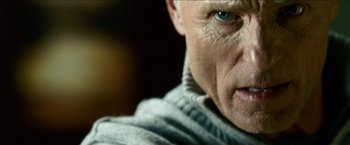 Movie still from “Cleaner” (2007), directed by Renny Harlin – An older man with a blue eye stares at the camera; Close Up shot, Low angle