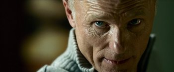 Movie still from “Cleaner” (2007), directed by Renny Harlin – An older man with a blue eye stares at the camera; Extreme Close Up shot, Low angle