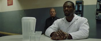 A man sitting at a table in front of another man