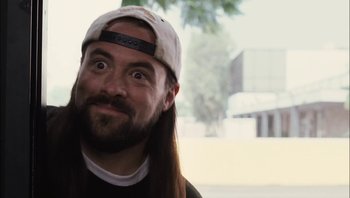 Movie still from “Clerks II” (2006), directed by Kevin Smith – A person with long hair wearing a hat; Close Up shot, Low angle