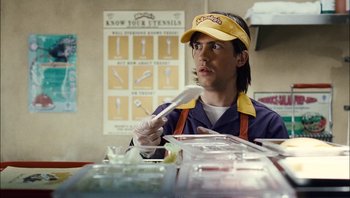 Movie still from “Clerks II” (2006), directed by Kevin Smith – A man in a yellow hat is holding a spoon; Close Up shot, Over the shoulder angle