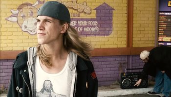 Movie still from “Clerks II” (2006), directed by Kevin Smith – A man with long blonde hair wearing a baseball cap; Close Up shot, Low angle