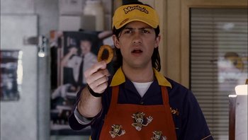 Movie still from “Clerks II” (2006), directed by Kevin Smith – A man holding a donut in his right hand; Close Up shot, High angle