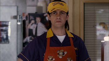 Movie still from “Clerks II” (2006), directed by Kevin Smith – A man wearing a goofy hat and apron; Close Up shot, Over the shoulder angle