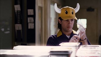 Movie still from “Clerks II” (2006), directed by Kevin Smith – A man wearing a viking hat while looking at his cell phone; Medium shot, Low angle