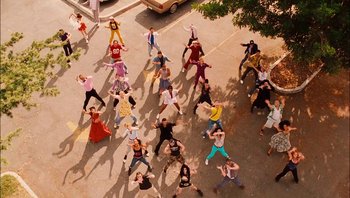 Movie still from “Clerks II” (2006), directed by Kevin Smith – An aerial view of a group of people dancing on the street; Extreme Wide shot, Overhead angle