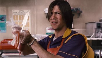Movie still from “Clerks II” (2006), directed by Kevin Smith – A man holding a pair of scissors while wearing an apron; Medium shot, Low angle