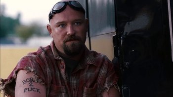 Movie still from “Clerks II” (2006), directed by Kevin Smith – A man in a plaid shirt and sunglasses; Close Up shot, Low angle