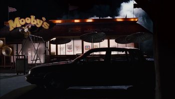 Movie still from “Clerks II” (2006), directed by Kevin Smith – A car parked in front of a restaurant at night; Wide shot, High angle