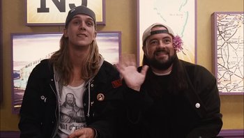 Movie still from “Clerks II” (2006), directed by Kevin Smith – Two men sitting next to each other in front of a map; Medium shot, Over the shoulder angle