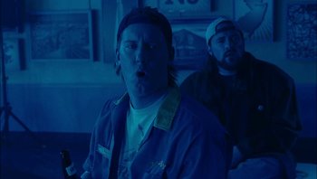 Movie still from “Clerks II” (2006), directed by Kevin Smith – Two men in a dark room , one of whom is holding a bottle of beer; Medium shot, Low angle