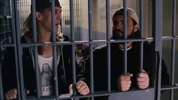 Movie still from “Clerks II” (2006), directed by Kevin Smith – Two men are standing behind a metal fence; Medium shot, Low angle