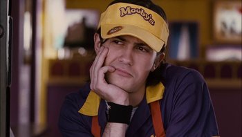 Movie still from “Clerks II” (2006), directed by Kevin Smith – A man in a yellow hat is leaning on his hand; Close Up shot, High angle
