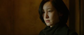 Movie still from “Cliff Walkers” (2021), directed by Yimou Zhang – A person wearing a black jacket; Close Up shot, Over the shoulder angle