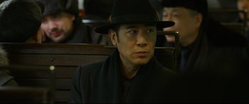 Movie still from “Cliff Walkers” (2021), directed by Yimou Zhang – A man in a black hat and a black coat; Close Up shot, Over the shoulder angle