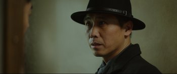 Movie still from “Cliff Walkers” (2021), directed by Yimou Zhang – A person wearing a hat; Close Up shot, Low angle