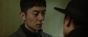 Movie still from “Cliff Walkers” (2021), directed by Yimou Zhang – A person wearing a sweater; Close Up shot, Over the shoulder angle