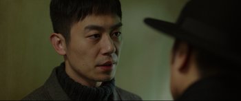 Movie still from “Cliff Walkers” (2021), directed by Yimou Zhang – A person wearing a hat; Close Up shot, Over the shoulder angle