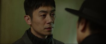 Movie still from “Cliff Walkers” (2021), directed by Yimou Zhang – A person wearing a sweater; Close Up shot, Over the shoulder angle