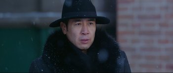 Movie still from “Cliff Walkers” (2021), directed by Yimou Zhang – A man wearing a black hat and a black coat; Close Up shot, Low angle