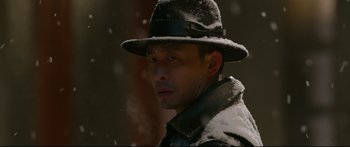 Movie still from “Cliff Walkers” (2021), directed by Yimou Zhang – A man wearing a hat in the snow; Close Up shot, Low angle