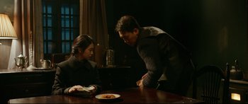 Movie still from “Cliff Walkers” (2021), directed by Yimou Zhang – A man and a woman at a table with a plate of food; Medium shot, Over the shoulder angle