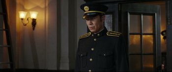 Movie still from “Cliff Walkers” (2021), directed by Yimou Zhang – A man in a military uniform is standing in a room; Medium shot, Over the shoulder angle