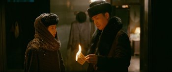 Movie still from “Cliff Walkers” (2021), directed by Yimou Zhang – A man and woman are holding a lit candle; Medium shot, Over the shoulder angle