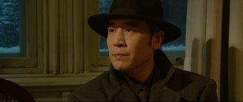 Movie still from “Cliff Walkers” (2021), directed by Yimou Zhang – A man wearing a hat and a tie; Close Up shot, Low angle