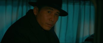 Movie still from “Cliff Walkers” (2021), directed by Yimou Zhang – A man wearing a black hat and a black jacket; Close Up shot, Low angle