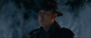 Movie still from “Cliff Walkers” (2021), directed by Yimou Zhang – A man wearing a black hat and a black jacket; Close Up shot, Low angle