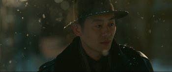 Movie still from “Cliff Walkers” (2021), directed by Yimou Zhang – A man wearing a hat and a jacket; Close Up shot, Over the shoulder angle