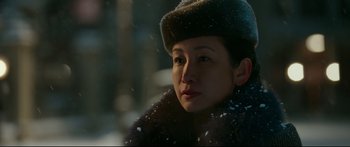A woman wearing a fur hat in the snow