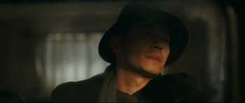 Movie still from “Cliff Walkers” (2021), directed by Yimou Zhang – A man wearing a hat and a suit; Close Up shot, Low angle