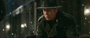 Movie still from “Cliff Walkers” (2021), directed by Yimou Zhang – A man wearing a hat and a coat in the snow; Close Up shot, Low angle