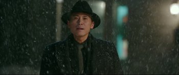 Movie still from “Cliff Walkers” (2021), directed by Yimou Zhang – A man wearing a hat and a suit in the snow; Close Up shot, Low angle