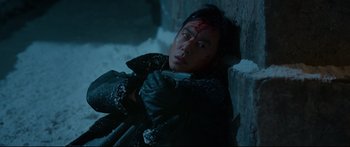 Movie still from “Cliff Walkers” (2021), directed by Yimou Zhang – A man with a knife in his hand leaning against a wall; Close Up shot, Overhead angle