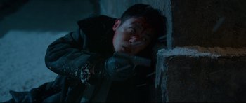 Movie still from “Cliff Walkers” (2021), directed by Yimou Zhang – A man with a knife in his hand is leaning against a wall; Close Up shot, Low angle
