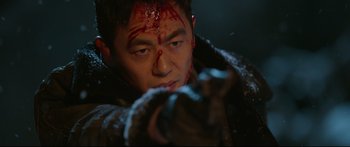 Movie still from “Cliff Walkers” (2021), directed by Yimou Zhang – A man with blood all over his face; Close Up shot, Over the shoulder angle