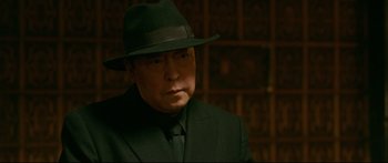 Movie still from “Cliff Walkers” (2021), directed by Yimou Zhang – A man wearing a suit and a hat; Close Up shot, Over the shoulder angle
