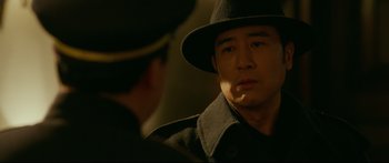 Movie still from “Cliff Walkers” (2021), directed by Yimou Zhang – A man wearing a hat and a coat; Close Up shot, Over the shoulder angle