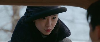 Movie still from “Cliff Walkers” (2021), directed by Yimou Zhang – A young woman wearing a hat and a coat; Close Up shot, Over the shoulder angle