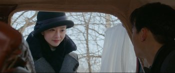 Movie still from “Cliff Walkers” (2021), directed by Yimou Zhang – A woman wearing a black hat and a black coat; Close Up shot, Over the shoulder angle