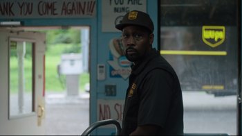 Movie still from “The Dead Don't Die” (2019), directed by Jim Jarmusch – A man standing in front of a window; Medium shot, Over the shoulder angle